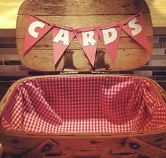 an old suitcase with a red and white gingham cloth lining the bottom that says cards