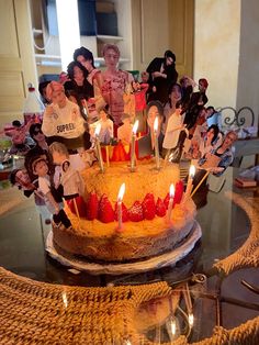 a birthday cake with candles on top of it and many figurines in the background