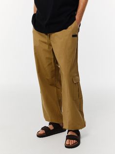 Editor's NotesThese pants from V2 have various styling with drawstrings at the waist and hem.- Banding closure- String at the waist- String at the hem- Wide fit silhouette- Basic and versatile itemMeasurements(in.)M/L- Waist: 12.59 / 13.38 in.- Thigh: 14.96 / 15.55 in.- Hip: 22.83 / 23.62 in.- Front rise: 14.56 / 14.96 in.- Hem: 11.41 / 12.20 in.- Total length: 41.14 / 41.73 in.Model infoMan - Height: 6'06 Fitting size LComposition & Care- 100% Cotton- Please check the care labelDesigner- b Utility Style Drawstring Trousers, Utility Straight Leg Pants With Drawstring, Utility Parachute Pants With Drawstring And Relaxed Fit, Utility Parachute Pants With Drawstring, Khaki Utility Pants With Elastic Waistband, Utility Style Trousers With Drawstring, Utility Bottoms With Drawstring And Loose Fit, Utility Bottoms With Drawstring And Loosely Fitted Hips, Utility Style Relaxed Fit Sweatpants With Drawstring