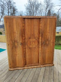 a large wooden cabinet sitting on top of a wooden deck