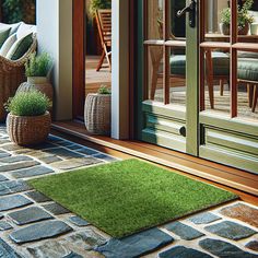 a green door mat sitting on top of a wooden floor next to a chair and potted plant