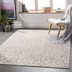 a living room area with a chair, window and leopard print rug on the floor