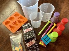 some plastic cups are sitting on a table with other crafting supplies around them, including markers and pencils