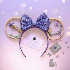 there is a purple mouse ears with blue sequins and a bow on it