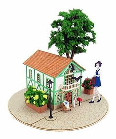 a miniature model of a house with a tree on the roof and people walking around