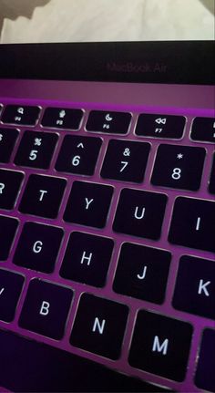 a purple laptop computer sitting on top of a desk