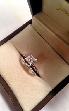 an engagement ring in a box with the lid open and diamond set on it's side