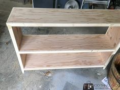 a wooden shelf sitting on top of a cement floor