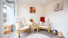 two white chairs sitting next to each other in a room