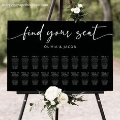 a black and white wedding seating sign with flowers