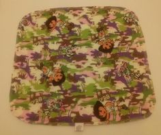 a square shaped object with cartoon characters on it's side and pink, green, purple, and white camouflage print