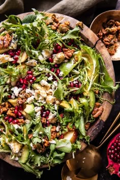 a salad with nuts, avocado and pomegranates in a wooden bowl