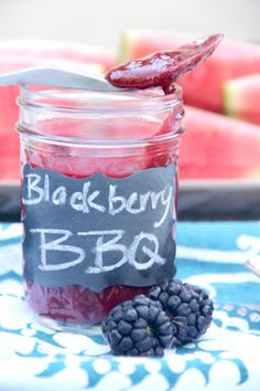 a jar filled with blackberry bbq next to some blackberries