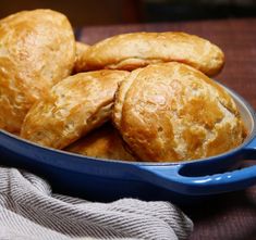 a blue pan filled with pastries on top of a table