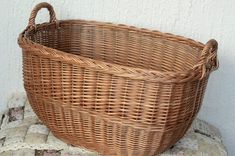 a large wicker basket sitting on top of a cushion next to a white wall