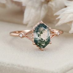 a green and white ring sitting on top of a table next to a flower bouquet