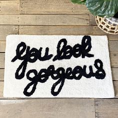 a door mat with the words you bele goggous on it next to a potted plant