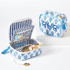 an open blue and white suitcase sitting on top of a table next to another bag