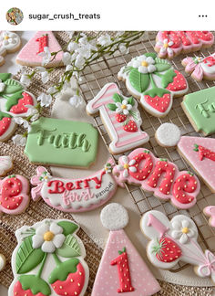 some decorated cookies are sitting on a cooling rack with the words happy 1st birthday written in frosting