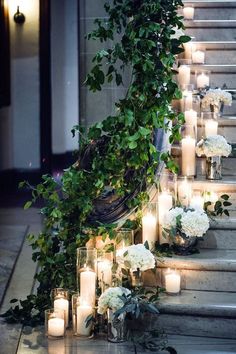 candles are lit on the steps with flowers and greenery growing up each one side