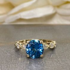 a blue and white diamond ring sitting on top of a table