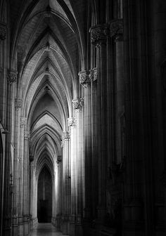 the interior of a large cathedral with tall columns and arches is shown in black and white