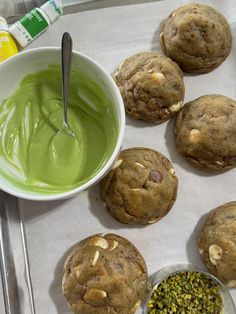 some cookies are sitting on a tray with green liquid in the bowl next to them