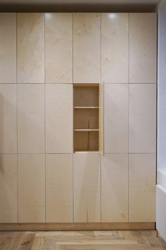 an empty room with white walls and wooden flooring on the wall is a book shelf