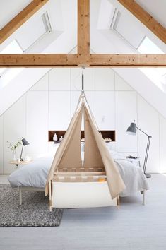 a bed with a teepee hanging from it's side in a loft bedroom