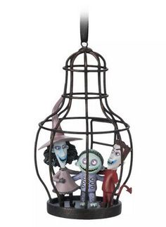 a metal cage with three figurines inside