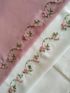 pink and white satin with embroidered flowers on the side, along with two different color fabrics