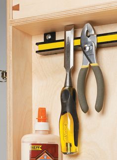 a cabinet door with tools hanging on the handle and some glue in front of it