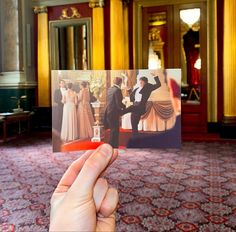 a person holding up a photo in front of a room