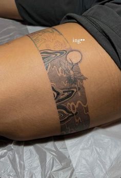 a person with a tattoo on their arm and leg sitting on a sheet of foil