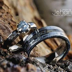 two wedding rings that are sitting on some rocks