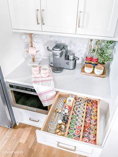 an open drawer in a kitchen filled with condiments and other items on the counter