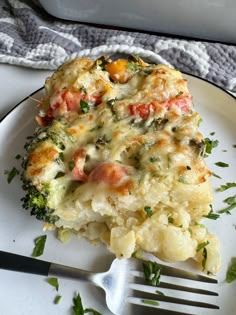 a piece of broccoli casserole on a white plate with a fork