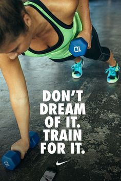 a woman doing push ups with blue dumbs on her feet and the words don't dream of it, train for it