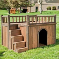 a dog house made out of wood with stairs leading up to the top and bottom