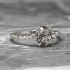 a close up view of an engagement ring with diamonds on the band and side stones