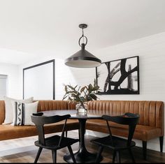 a dining room table with four chairs and a bench in front of the couches