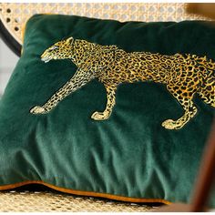 a green pillow with a gold leopard on it