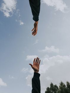 two hands reaching up into the sky