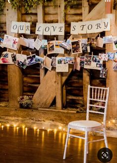 a white chair sitting on top of a wooden floor next to a wall covered in pictures