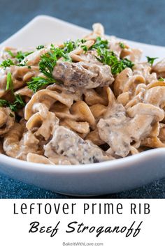 a white bowl filled with pasta covered in mushroom sauce and parsley on the side