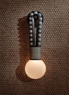 a light that is on the side of a wall next to a wallpapered wall