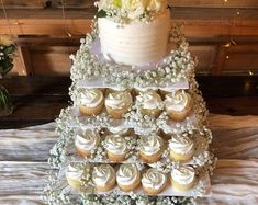 a wedding cake with cupcakes and flowers on it