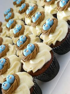 there are many cupcakes with blue and brown icing on top of them