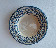 a blue and white bowl sitting on top of a wall