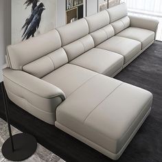 a large white couch sitting on top of a hard wood floor